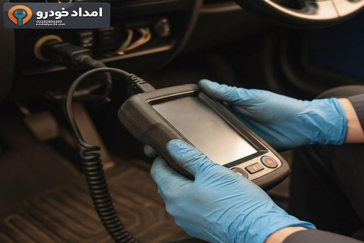 دست مکانیک در حال استفاده از دستگاه دیاگ قابل حمل با کابل OBD2